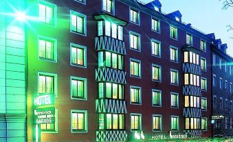 a large building with multiple floors , each containing different types of buildings and illuminated by green lights at Hotel Innsbruck