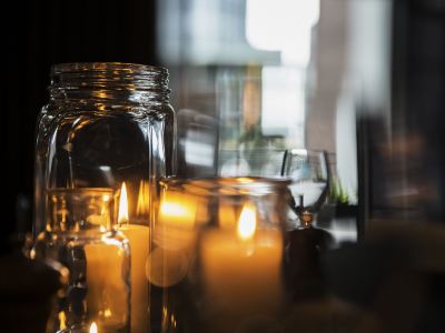 a table with a variety of lit candles and jars , creating a warm and inviting atmosphere at Ibis Melbourne Hotel and Apartments