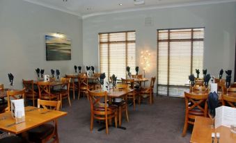 a large dining room with wooden tables and chairs arranged for a group of people to enjoy a meal together at Purdy Lodge