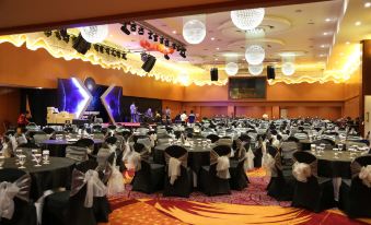 a large banquet hall filled with tables and chairs , ready for a formal event or a wedding reception at Galaxy Hotel Banjarmasin
