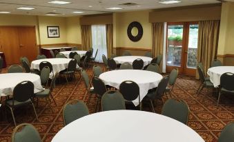 a large dining room with multiple round tables and chairs arranged for a party or event at The Inn at Holiday Valley