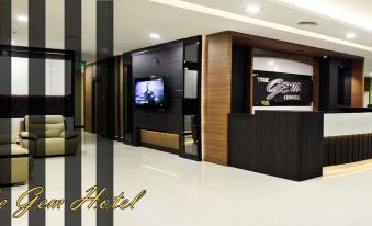 a modern hotel lobby with a reception desk and a tv screen displaying the grand , a brand name at The Gem Hotel Beaufort