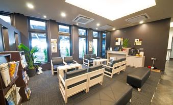 a modern waiting room with various seating options , including couches and chairs , arranged in a comfortable seating area at Hotel Route-Inn Fuji Chuo Koen Higashi