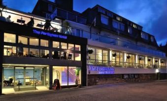 a modern building with multiple floors and balconies , illuminated by lights , under a clear blue sky at Portbyhan Hotel