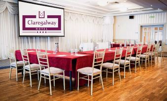 a conference room set up for a meeting , with tables and chairs arranged in a semicircle at Claregalway Hotel