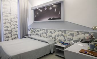 a hotel room with a comfortable bed , a nightstand , and a tv mounted on the wall at Hotel Italia