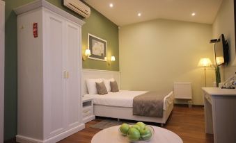 a cozy bedroom with a large bed , a round table , and two apples placed on the bed at Palisad