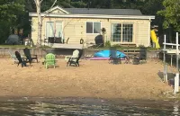 Lakeside Sunsets at this 3-bedroom lake cottage that sleeps 12 on Secord Lake.