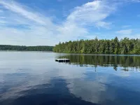 Stunning lakefront home with a boathouse, private dock, firepit and lake views