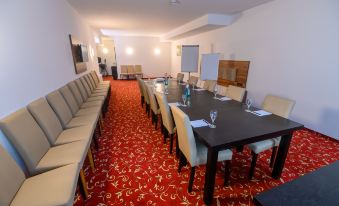 a long conference room with a long table , chairs , and a red carpet , set for a meeting at Hotel Luna