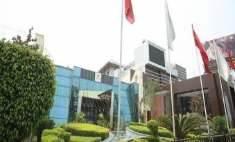 a modern building with red and white flags flying in front of it , surrounded by greenery at Hotel La