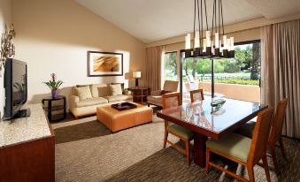 a living room with a couch , dining table , chairs , and a tv . also a dining table in the room at The Westin Rancho Mirage Golf Resort & Spa