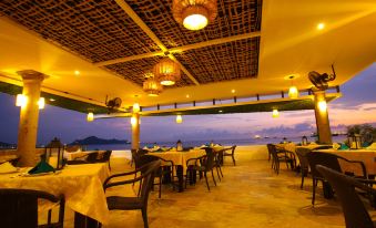 a restaurant with tables and chairs is set up on a beach , with a view of the ocean at Hotel Marbella