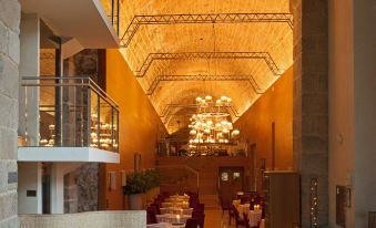 a dining room with a large table , chairs , and a chandelier hanging from the ceiling at Parador de Santo Estevo