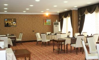 a dining room with several chairs and tables set up for a meal , creating a cozy atmosphere at Sword Hotel