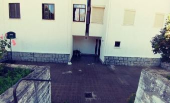 a white building with a dirt floor and a black object on the ground next to it at Casa Sierra