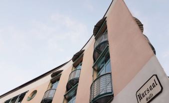 "a modern building with curved balconies and a sign reading "" henry "" is shown against a blue sky" at Hotel Esplanade