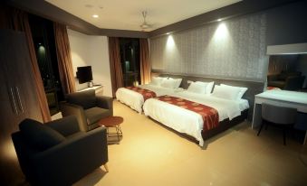 a hotel room with two beds , one on the left and one on the right side of the room at Star Well Hotel