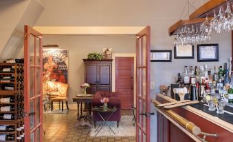 a wine cellar with multiple bottles of wine displayed , along with a bar area and dining table at Chamberlin Inn