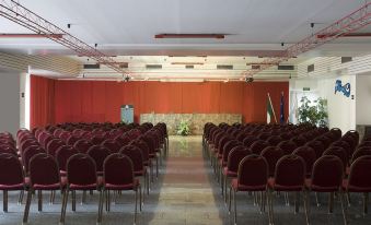 an empty conference room with rows of chairs and a podium , ready for a presentation or meeting at Hotel Califfo