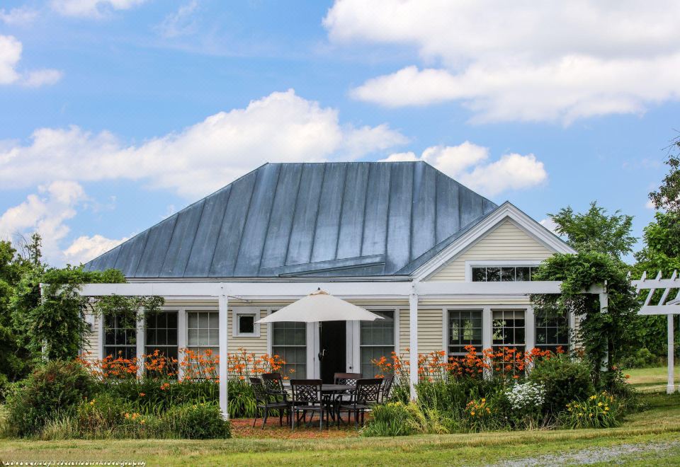 a large house with a metal roof and a patio set in front of it at Whitford House