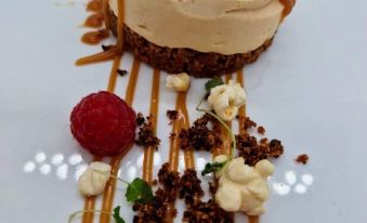 a dessert with a scoop of ice cream and a variety of toppings , including nuts and berries at The Woolpack Inn