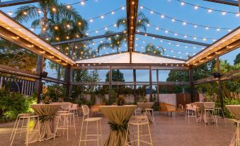 a dining area with tables and chairs set up for a party , surrounded by trees at Marion Hotel