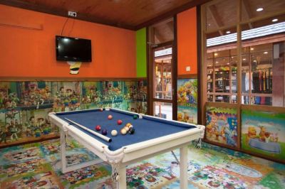 a room with a pool table , surrounded by colorful walls and a television mounted on the wall at Vilamendhoo Island Resort & Spa