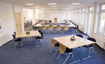 a large conference room with several tables and chairs arranged for a meeting or event at Fairway Hotel