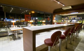 a modern restaurant with a bar and dining area , where several people are seated and enjoying their meals at Hotel America Igualada