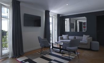 a modern living room with a black and white rug , a couch , and a tv at Hotel Bachaumont