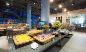 a buffet table with various food items and a bowl of fruit is set up in an open space at Beyond Patong