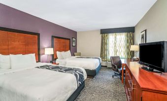 a hotel room with two beds , a desk , and a window , decorated in white and brown colors at La Quinta Inn & Suites by Wyndham Knoxville North I-75