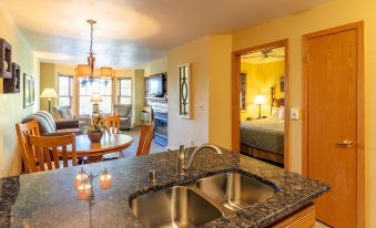 a kitchen with a granite countertop and stainless steel sink , next to an open door leading to a dining room at Newport Resort