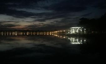 a nighttime scene with a calm body of water , a bridge , and a building illuminated by lights at Apartments Light