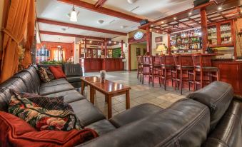 a spacious living room with multiple couches and chairs , creating a cozy atmosphere in a bar area at Hotel Golfer