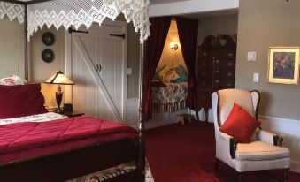 a cozy bedroom with a four - poster bed and a rocking chair , creating a comfortable sleeping area at Deerhill Inn