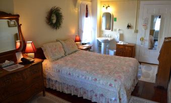 a bedroom with a bed , nightstands , and lamps , as well as a bathroom with a sink and mirror at Dowds Country Inn