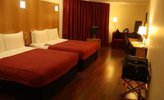 a hotel room with two beds , one on the left and one on the right side of the room at Station House Hotel Letterkenny