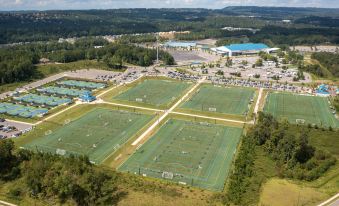 aerial view of a large sports complex with multiple fields , basketball courts , and a large building in the background at Holiday Inn Birmingham - Hoover