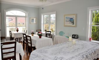 a dining room with a table set for two people , featuring a white tablecloth and chairs at The Sunset Inn