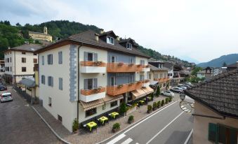 a city street with a row of multi - story buildings on the side , some of which are made of wood at Hotel Italia