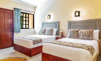 a bedroom with two beds , one on the left side and the other on the right side of the room at Hacienda San Miguel Yucatan
