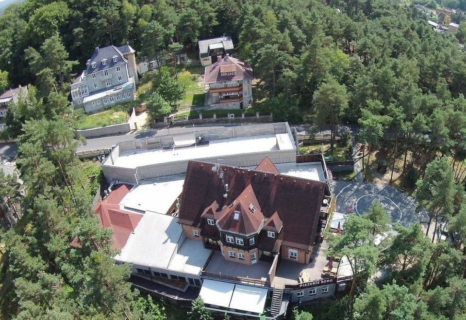 an aerial view of a large house surrounded by trees and a body of water at Hotel Berg