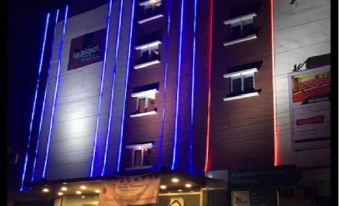 "a building with blue and red lights illuminating its exterior , and a sign that says "" psp "" on the side" at Budget Hotel