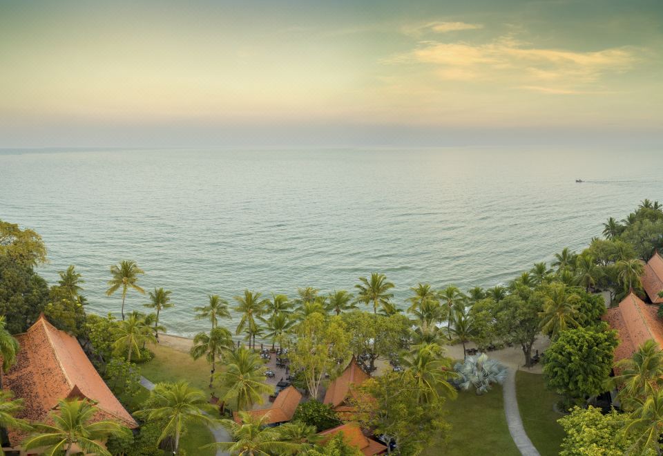 aerial view of a tropical beach resort with palm trees , a pool , and a sandy beach at Anantara Hua Hin Resort