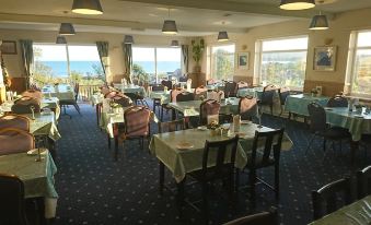 a large dining room with tables and chairs arranged for a group of people to enjoy a meal at Sandown Manor