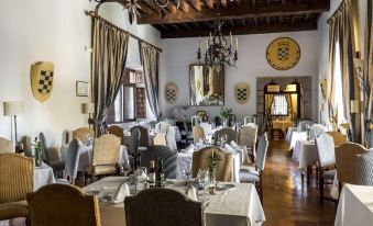 a large dining room with many tables and chairs arranged for a group of people to enjoy a meal together at Parador de Jarandilla