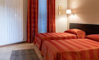 a hotel room with two beds , one on the left and one on the right side of the room at Hotel Del Corso