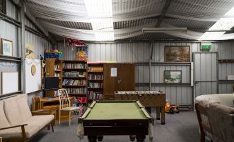 a room with a pool table , bookshelf , and other items such as an air conditioner at Inglewood Motel and Caravan Park Victoria